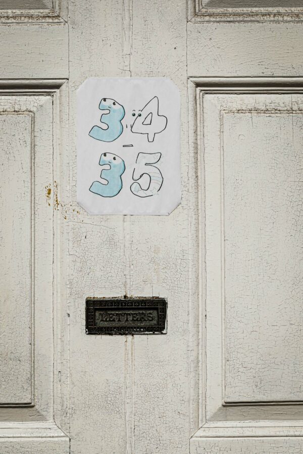 Front door with hand-drawn house numbers and a letter box embossed with LETTERS
